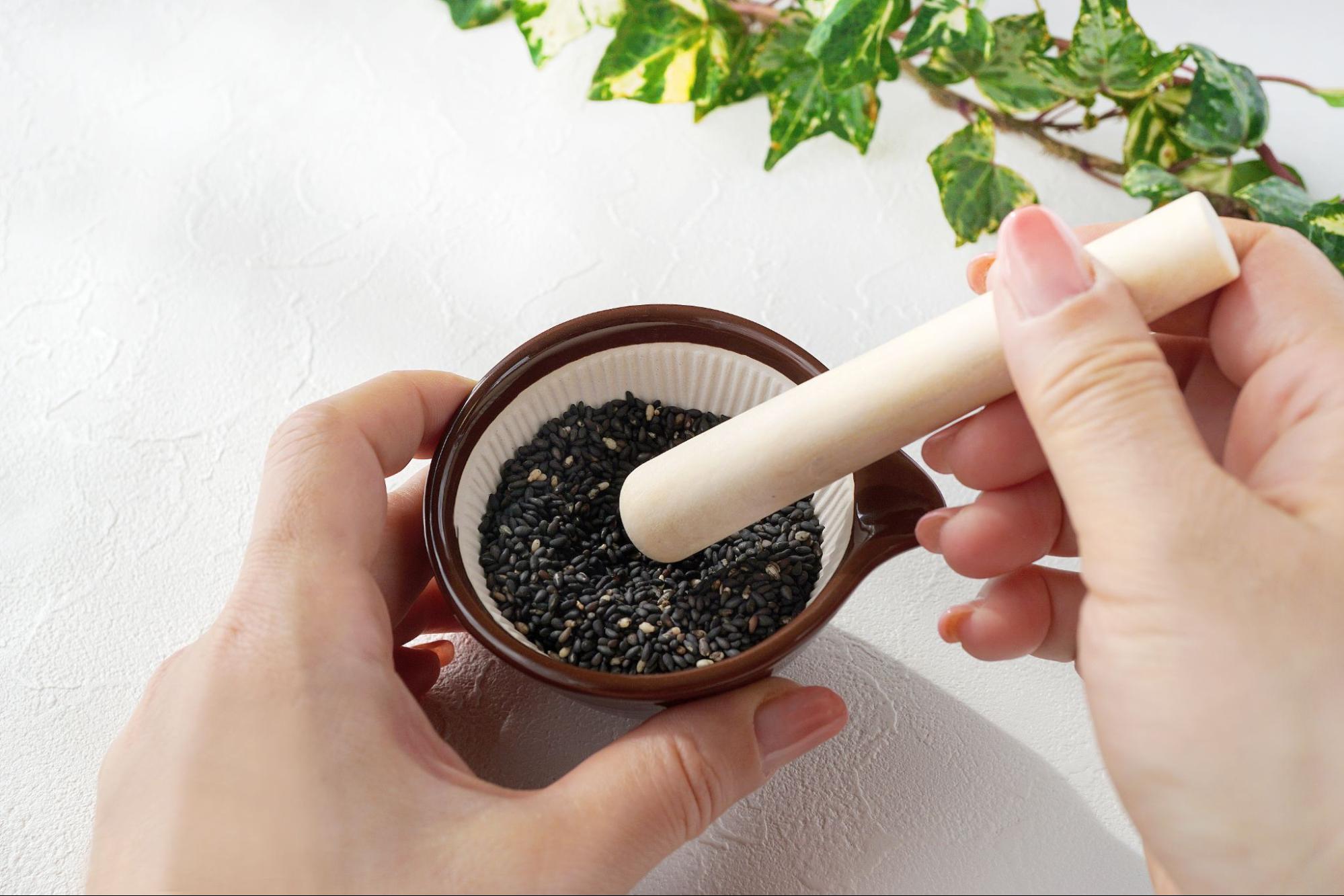 黒ゴマをする人の手